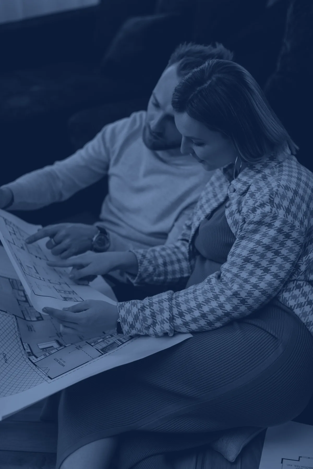 Couple penché sur les plans de sa future maison