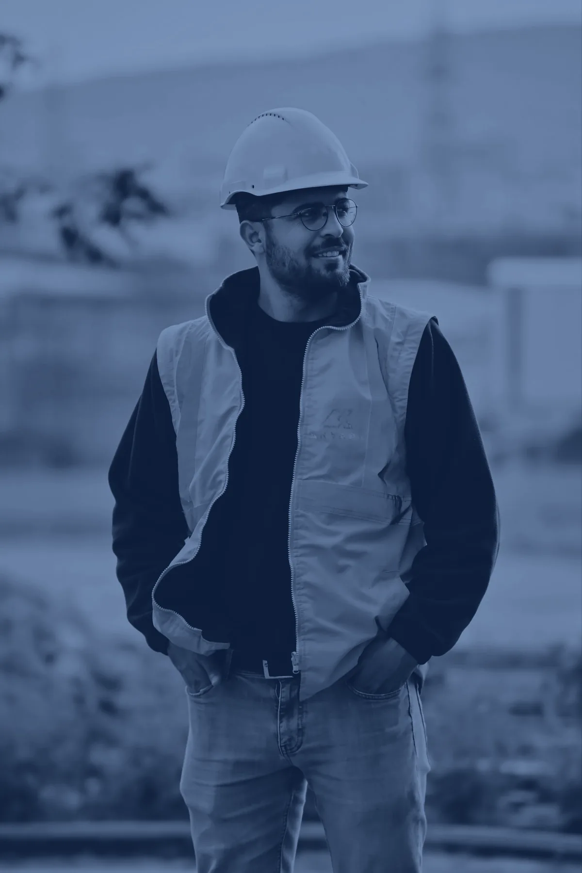 Artisan souriant, casque et gilet de chantier